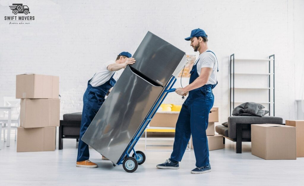 Two happy customers sitting on the tailgate of a loaded moving truck