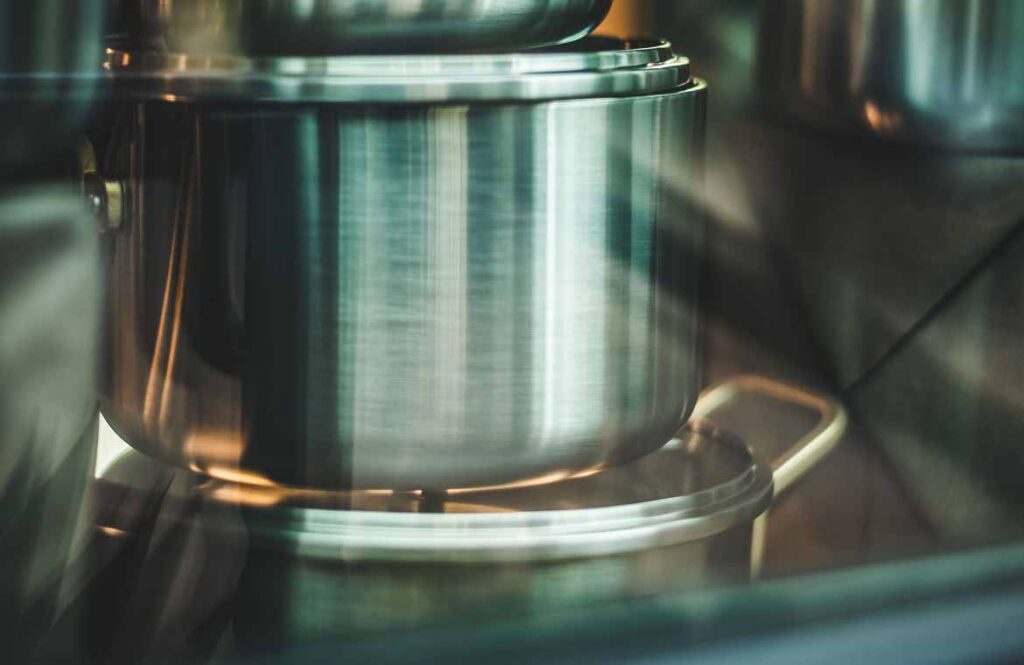 Saucepans nested inside each other with paper between them, ready to pack into a moving carton Saucepans nested inside each other with paper between them, ready to pack into a moving carton