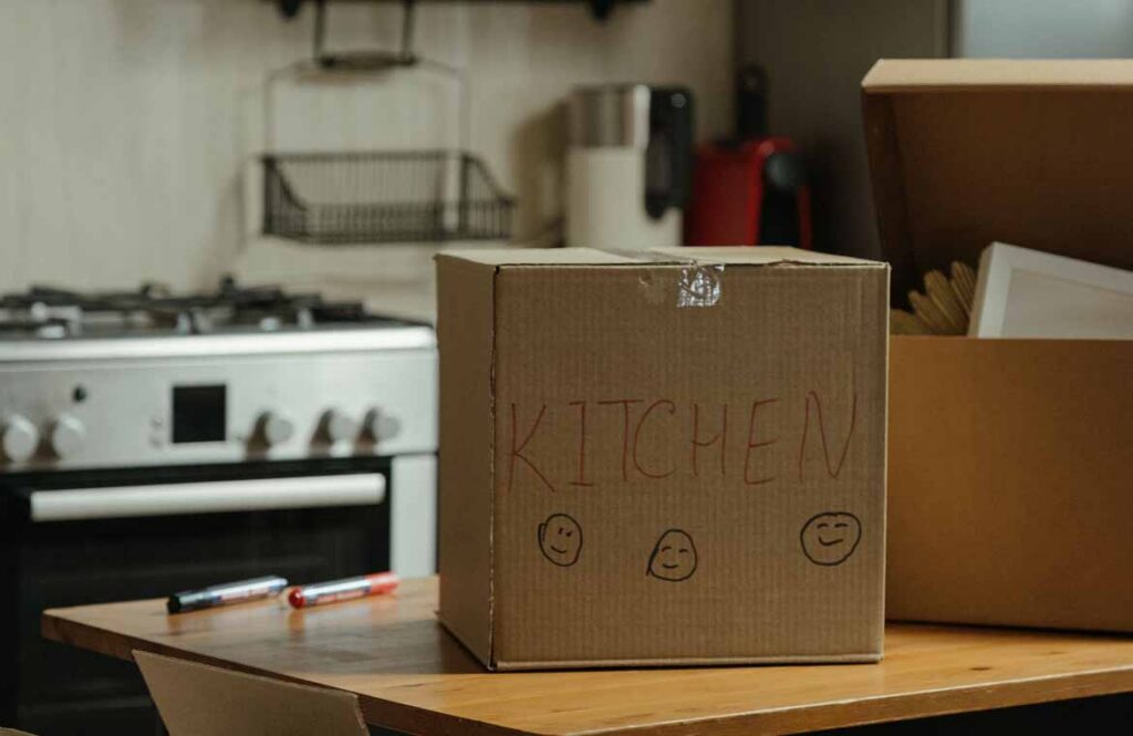Kitchen bench cleared and moving boxes ready for sorting the pantry