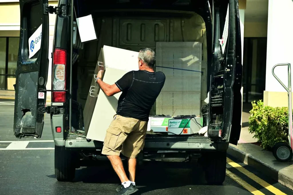 Movers blanket-wrapping and strapping furniture into a truck for the Auckland to Wellington run