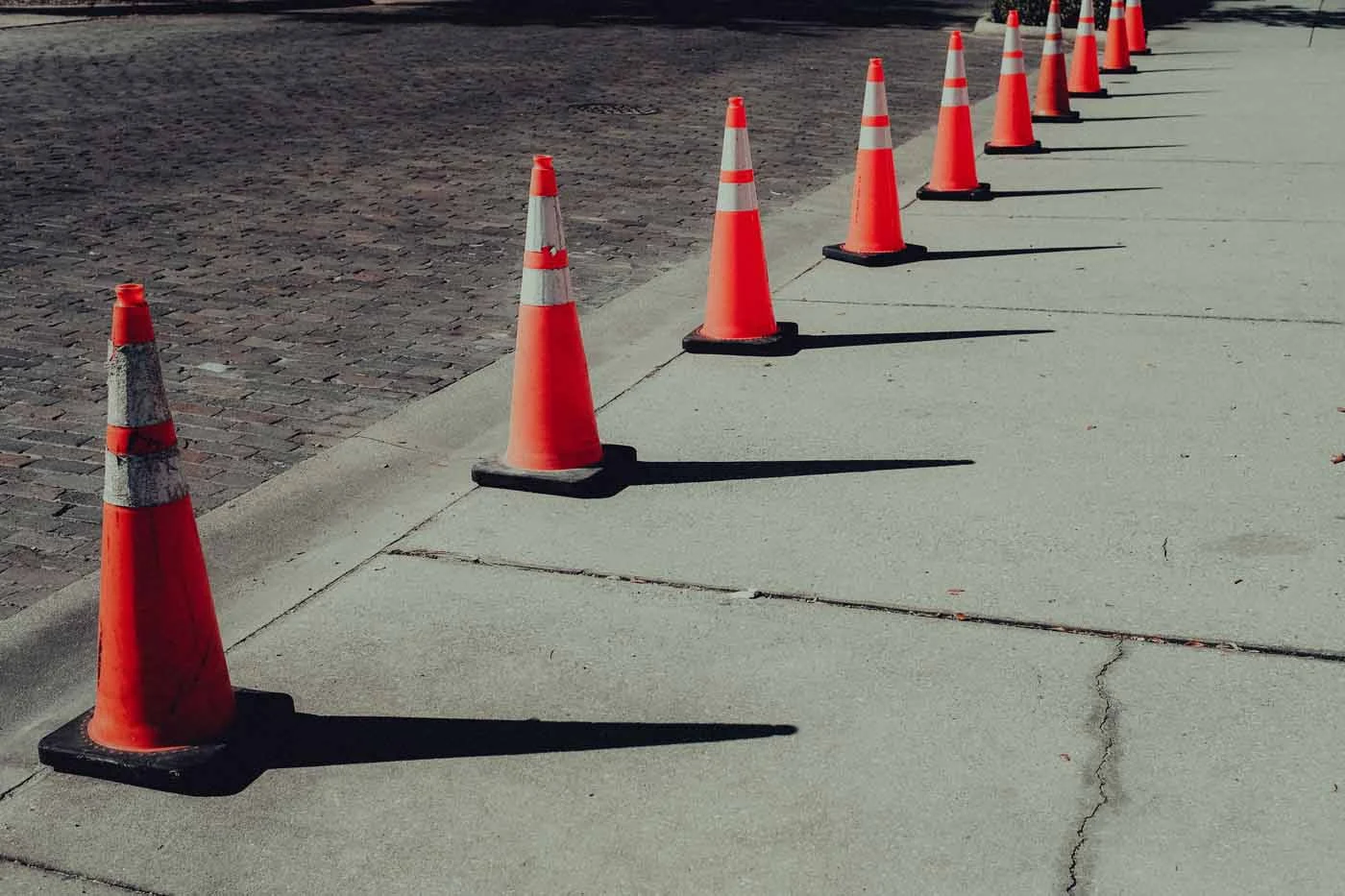 A row of orange traffic cones along a road surface