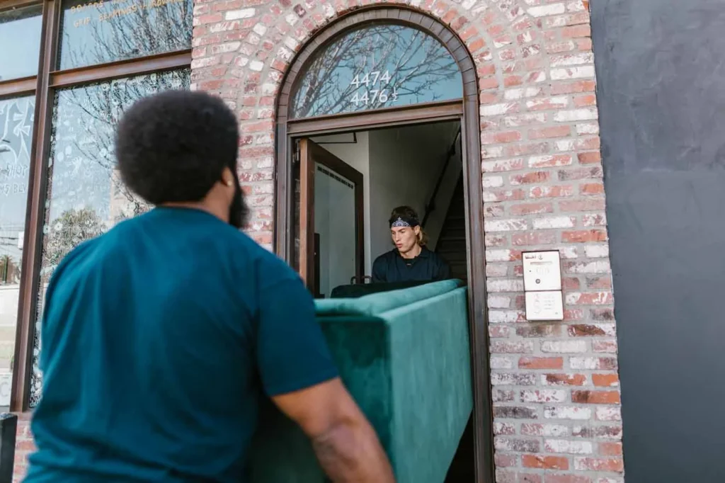 Movers carrying furniture into a West Auckland home on moving day